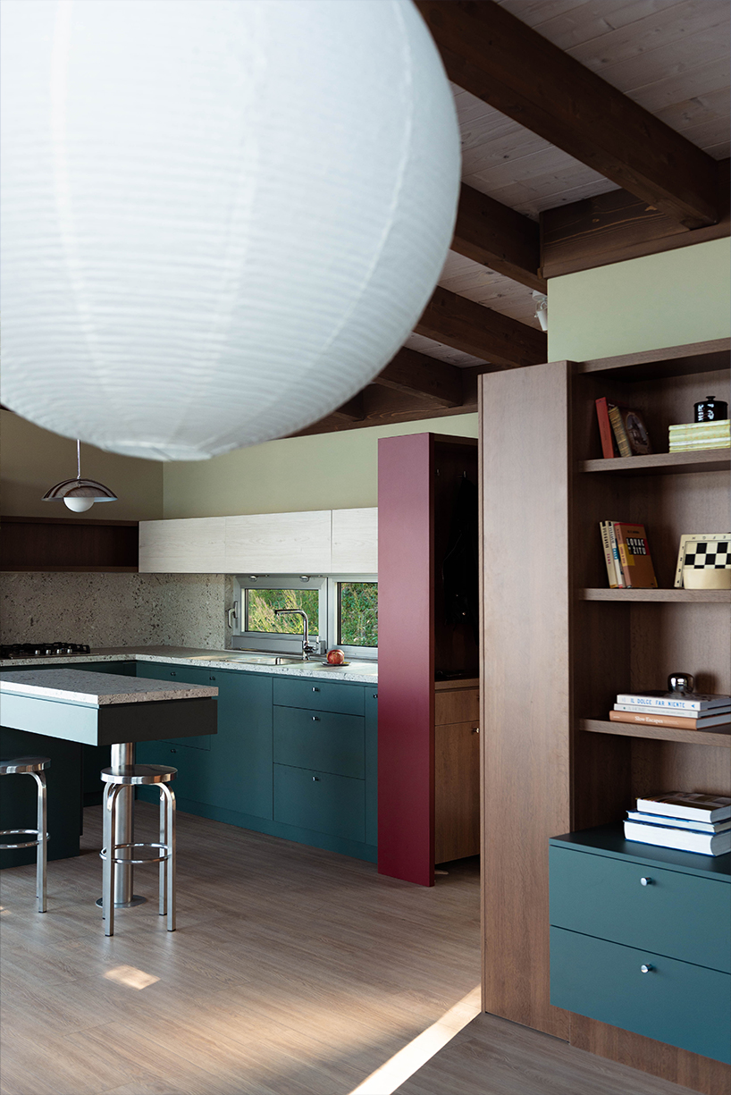 mono-pitch roof shields compact wooden cabin floating along river in serbia