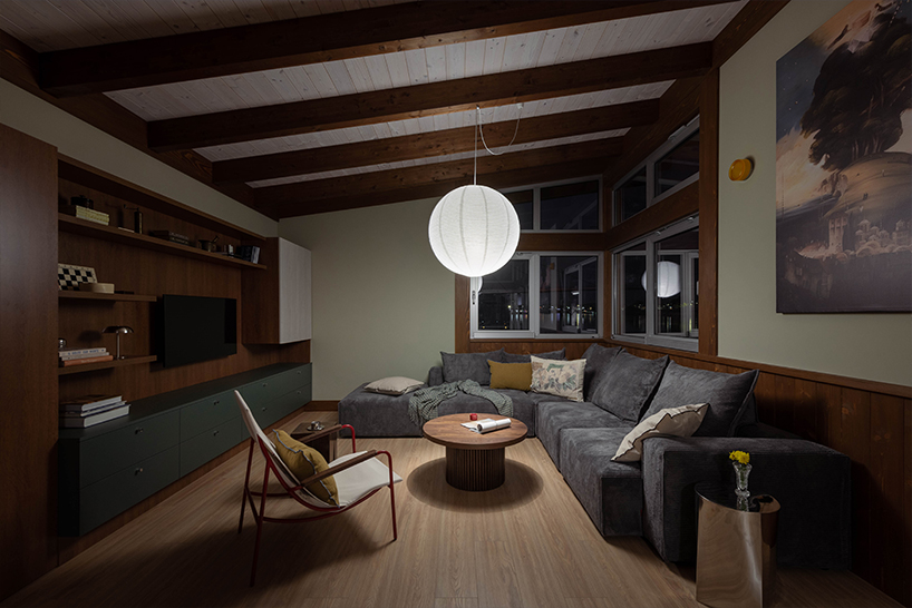 mono-pitch roof shields compact wooden cabin floating along river in serbia