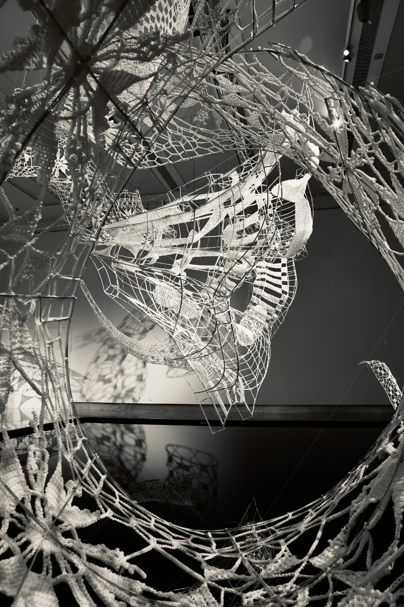crocheted zodiac animal installations by choi+shine suspend above dark body of water