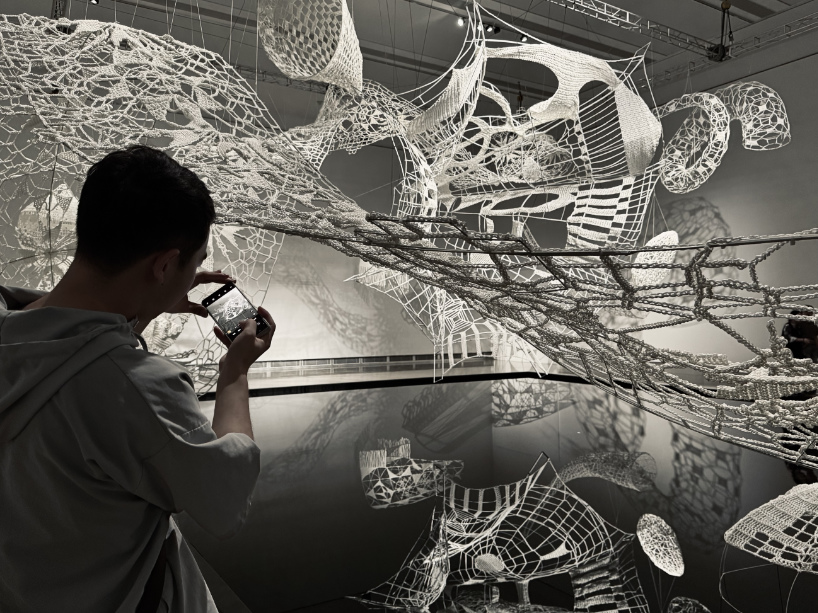 crocheted zodiac animal installations by choi+shine suspend above dark body of water