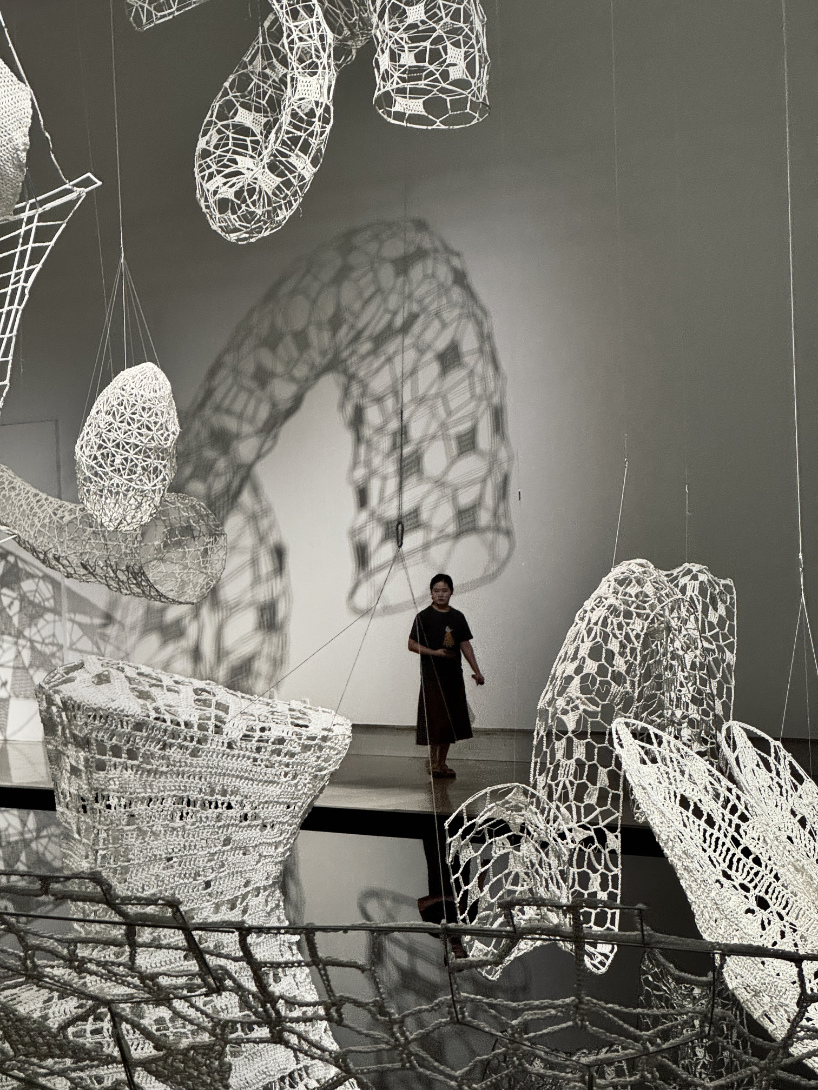 crocheted zodiac animal installations by choi+shine suspend above dark body of water