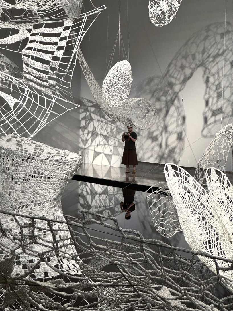 crocheted zodiac animal installations by choi+shine suspend above dark body of water