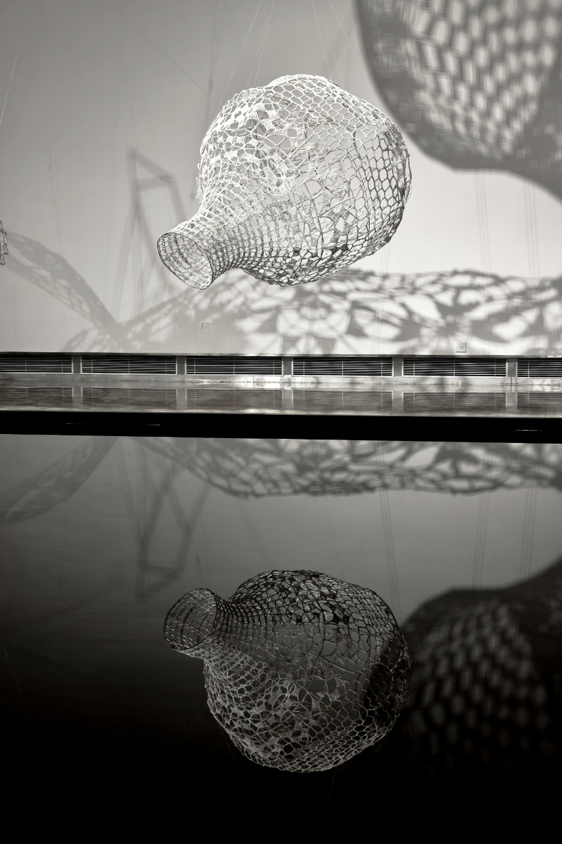 crocheted zodiac animal installations by choi+shine suspend above dark body of water