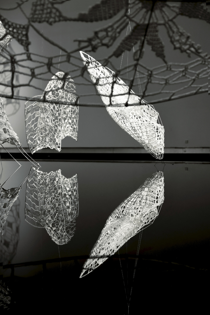 crocheted zodiac animal installations by choi+shine suspend above dark body of water