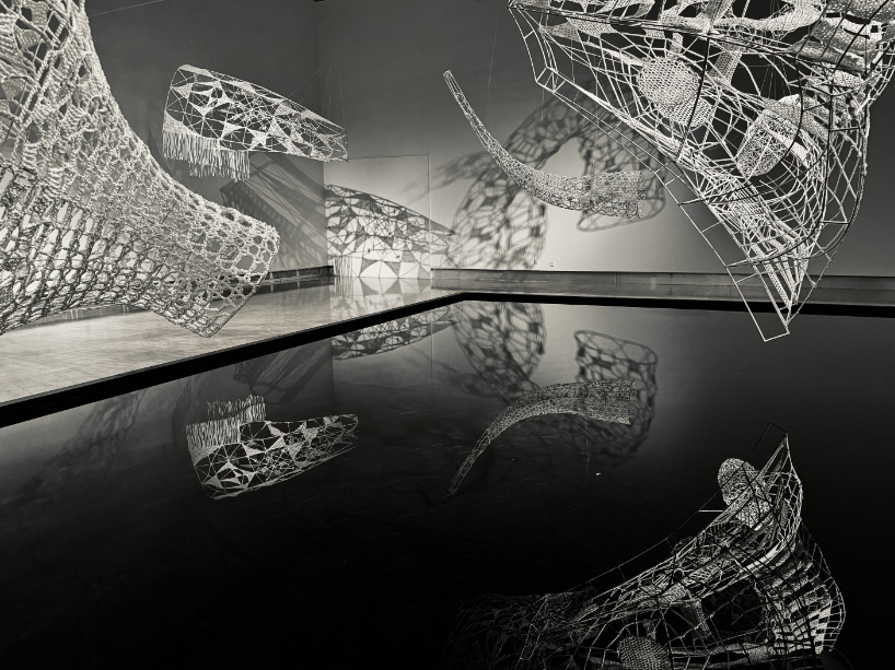 crocheted zodiac animal installations by choi+shine suspend above dark body of water