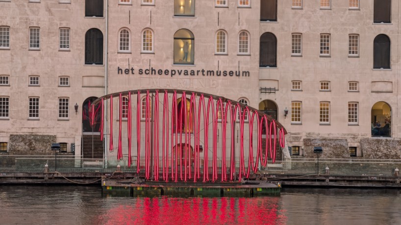 whale skeletal light installation glows red for amsterdam light festival