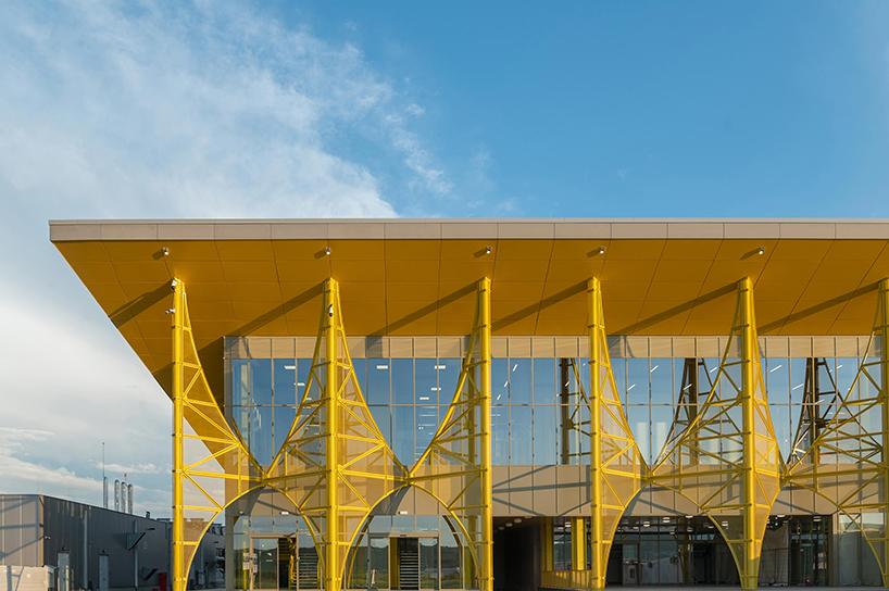 La ampliación de la terminal del aeropuerto rumano presenta arcos de metal amarillo translúcido