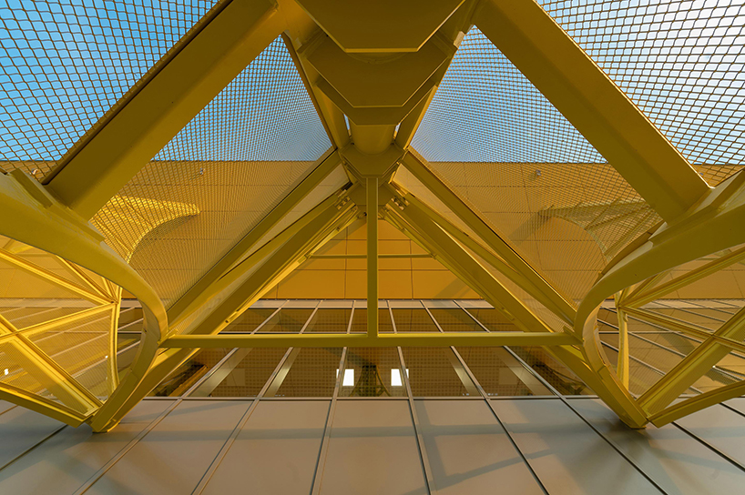 La ampliación de la terminal del aeropuerto rumano presenta arcos de metal amarillo translúcido