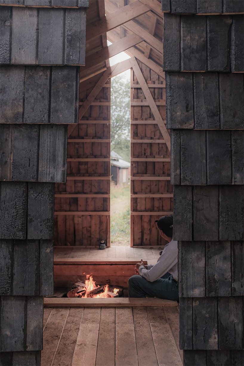 student collective builds fireplace shelter from reclaimed materials in northern norway