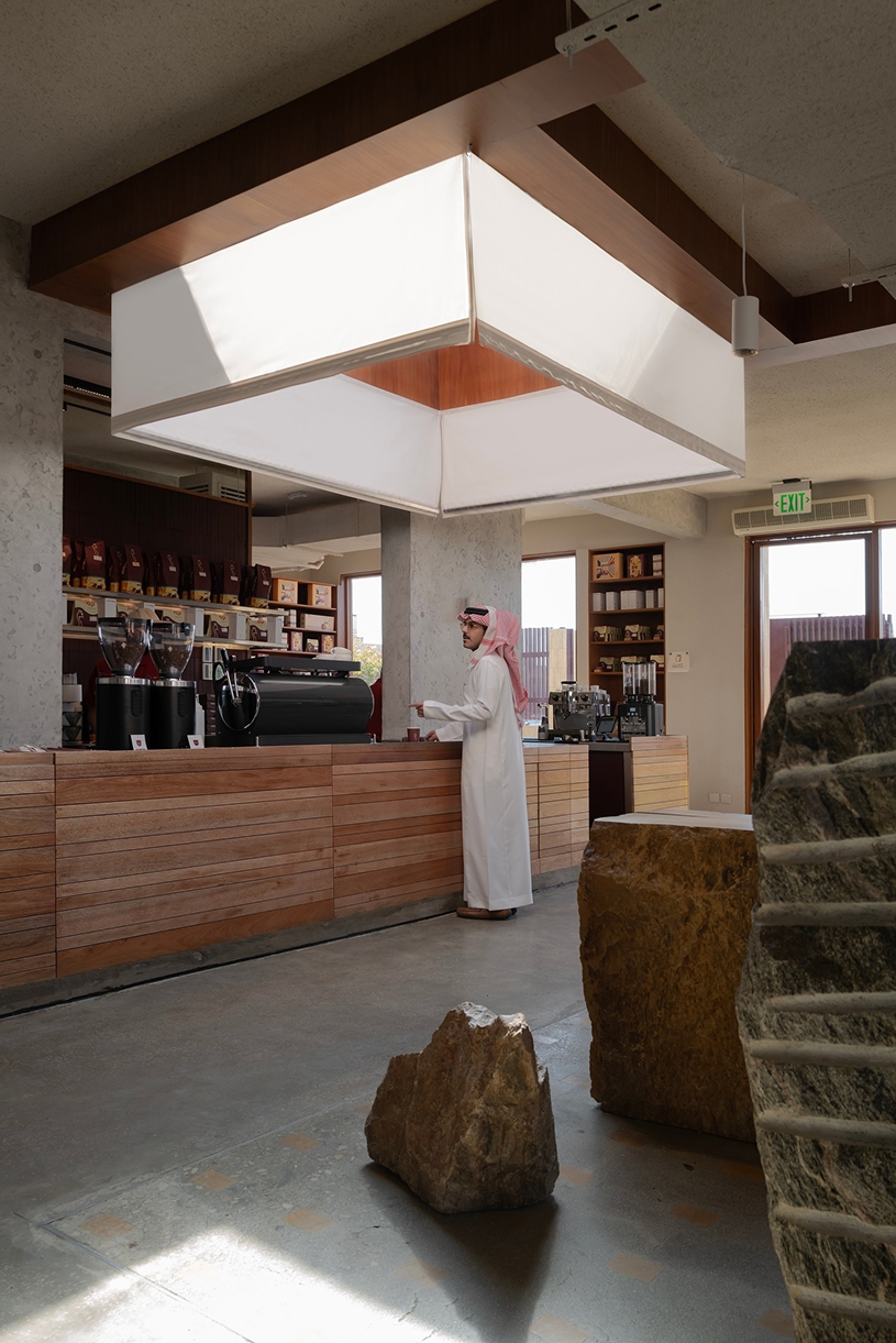 open planted courtyard organizes a caf&eacute; carved directly into rock in saudi arabia