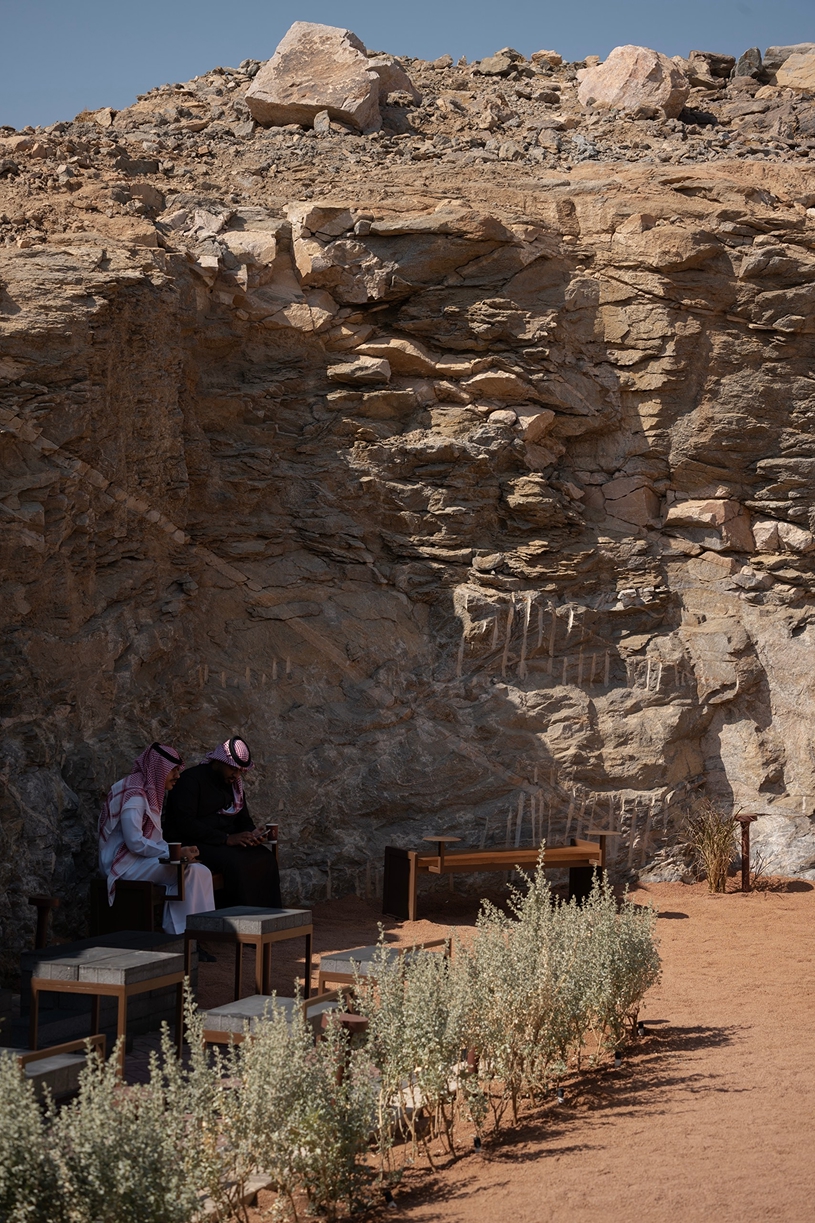 open planted courtyard organizes a caf&eacute; carved directly into rock in saudi arabia