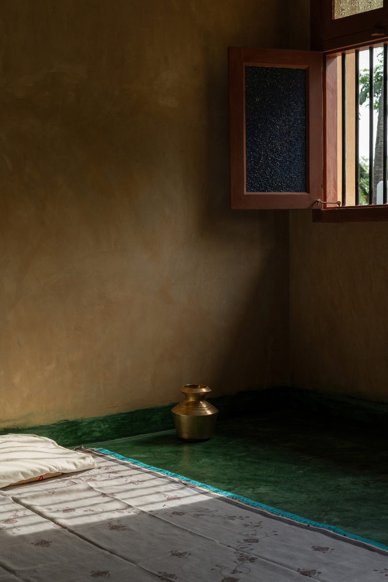 thousands of reclaimed bricks shape rural residence amid agricultural fields in india