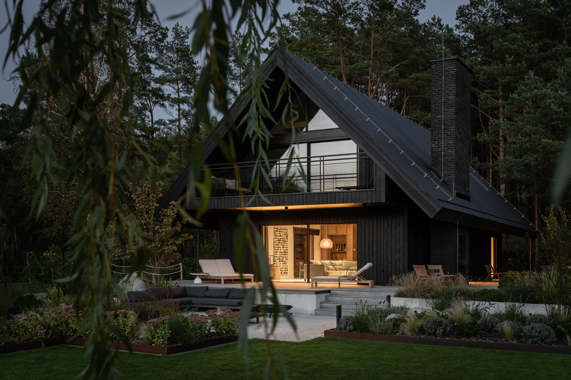 dark timber A&A house reinterprets traditional barn form within polish pine forest - 1