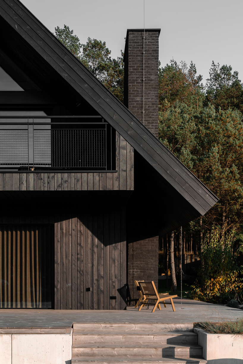dark timber A&A house reinterprets traditional barn form within polish pine forest - 3