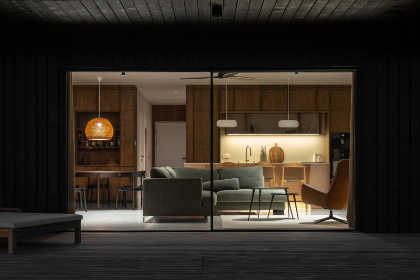 dark timber A&A house reinterprets traditional barn form within polish pine forest - 10