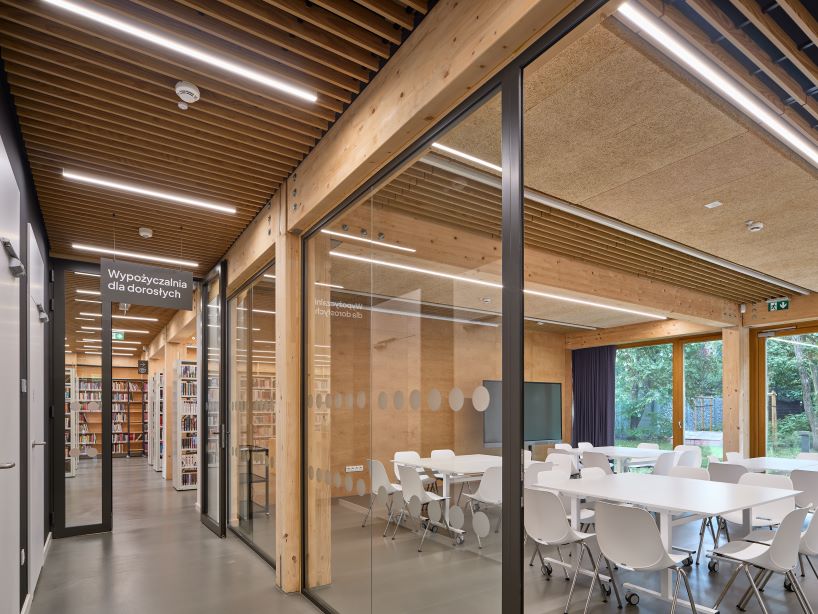 public library clad in washed timber integrates with warsaw's wooded neighborhood - 6
