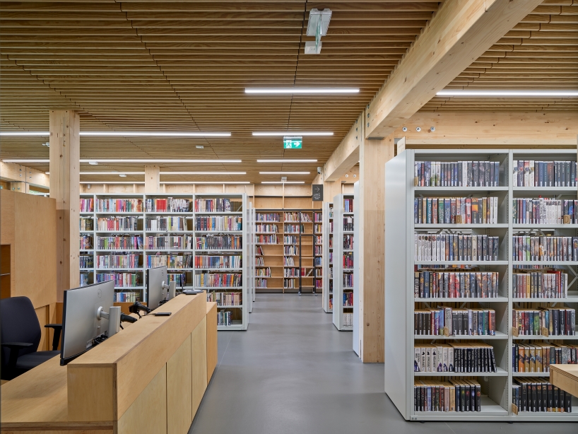 public library clad in washed timber integrates with warsaw's wooded neighborhood - 9