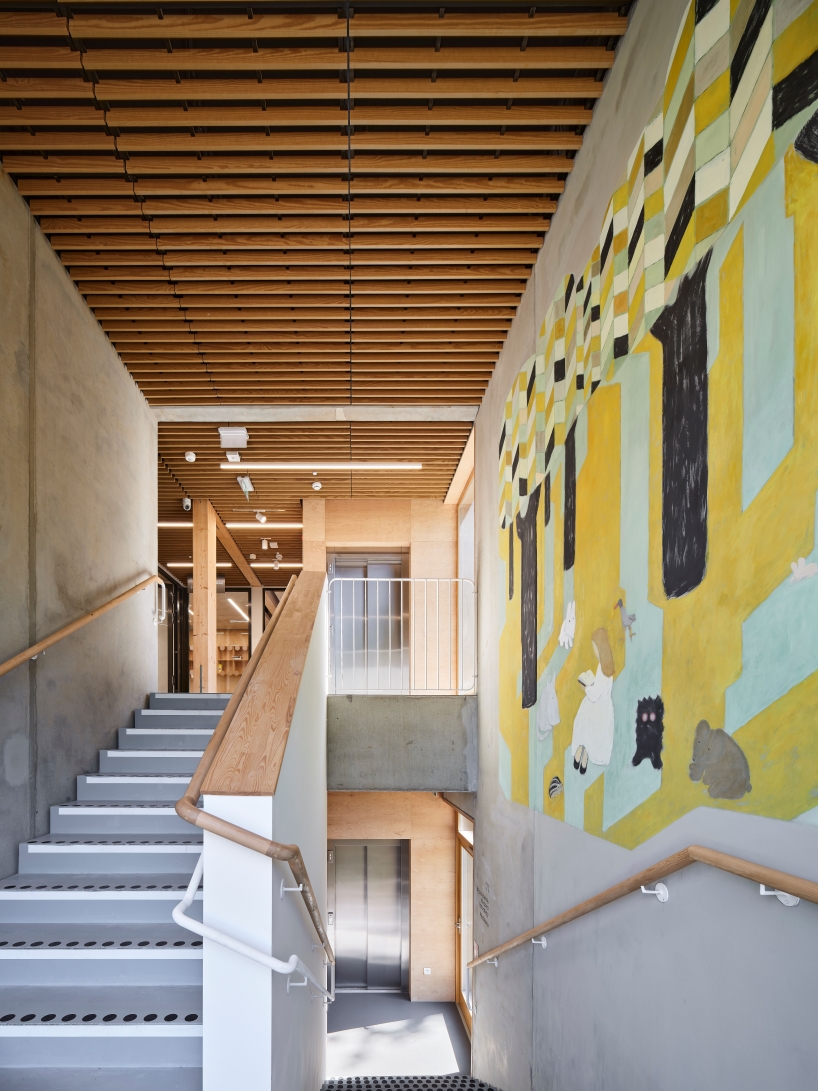 public library clad in washed timber integrates with warsaw's wooded neighborhood - 10