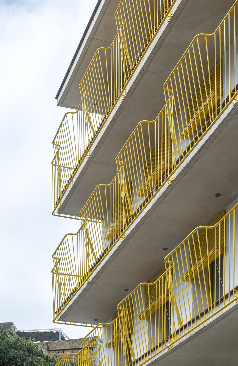 yellow steel, concrete, and circular openings revive corner building in spain as apart-hotel - 5