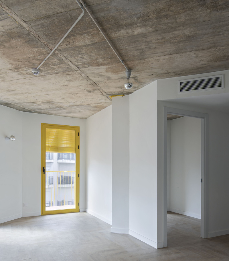 yellow steel, concrete, and circular openings revive corner building in spain as apart-hotel - 8