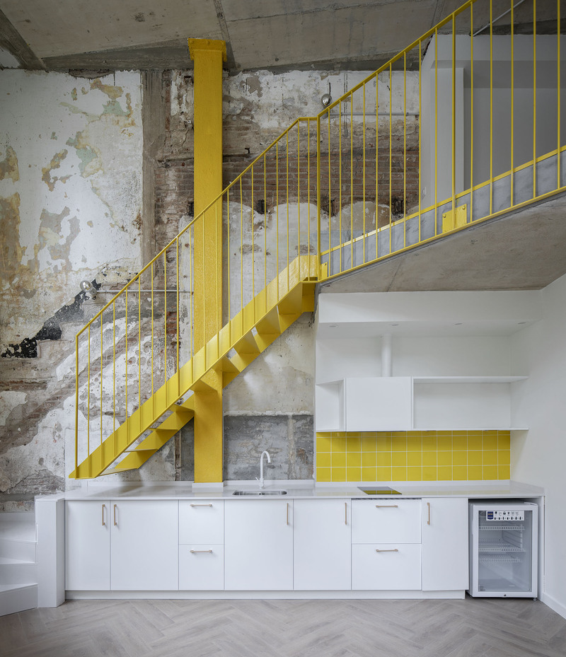 yellow steel, concrete, and circular openings revive corner building in spain as apart-hotel - 11