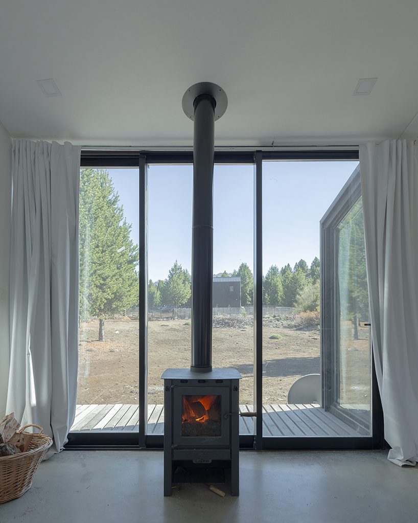 a modular cabin stands between river, forest, and mountains in argentine patagonia - 7