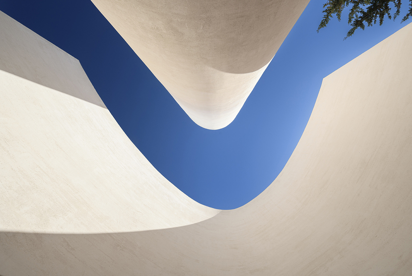 a flowing roof and fluid concrete walls frame the new santa barbara parish complex in sicily - 8
