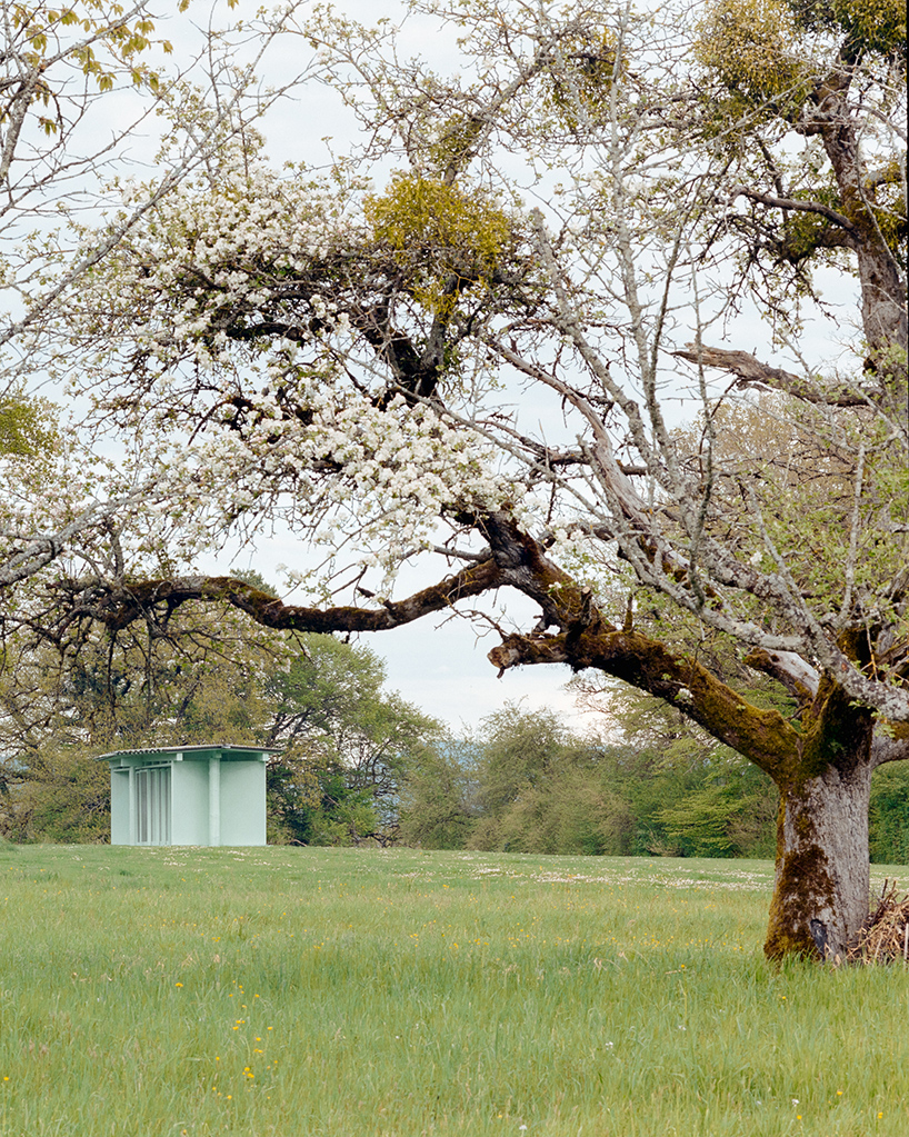 sliding timber frames and reused materials shape reversible pavilion within swiss meadow - 12