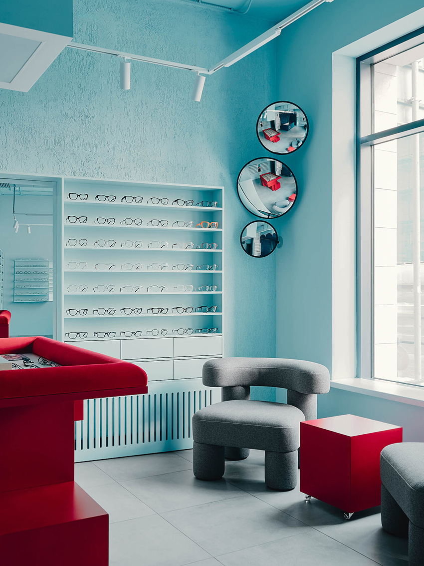 hubarch wraps an optics boutique in cold blue with single red interruption 4