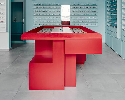 cool blue tones meet a vivid red counter inside hubarch’s new optics boutique