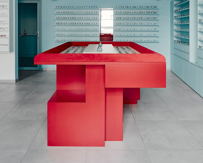 cool blue tones meet a vivid red counter inside hubarch’s new optics boutique