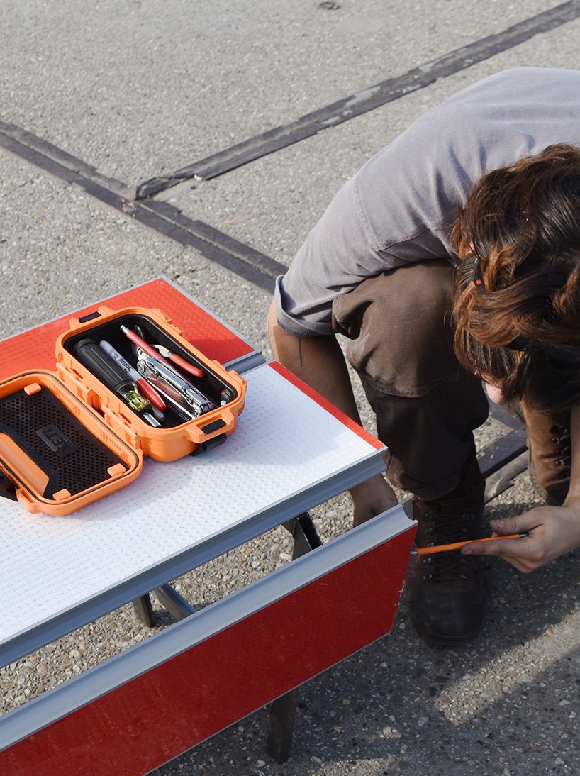 red-and-white aluminum safety barriers convert into public seating at dutch design week - 7