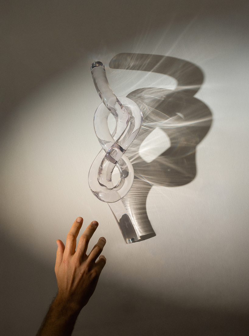 figure-eight knot casts into a glass light sculpture projecting shifting shadows - 2