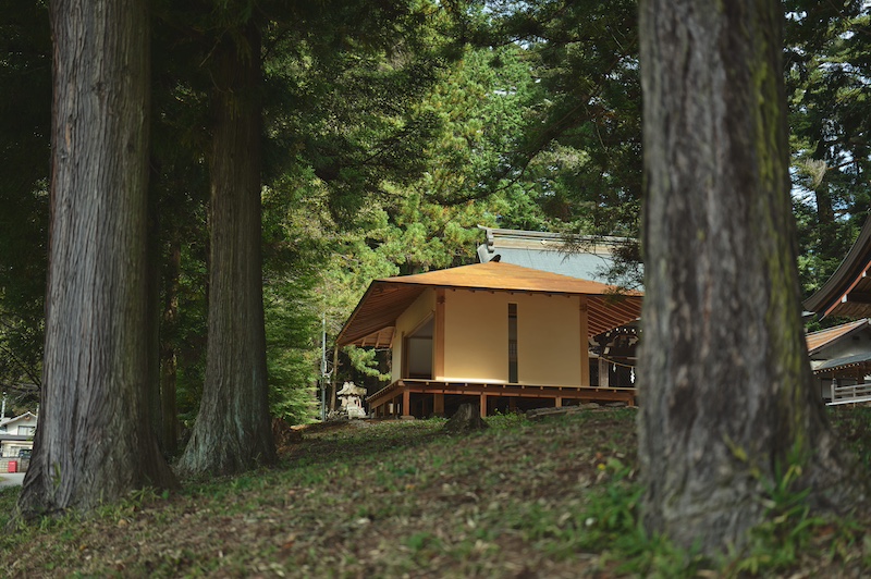 leaning timber frame anchors shrine office in japanese mountain valley - 1