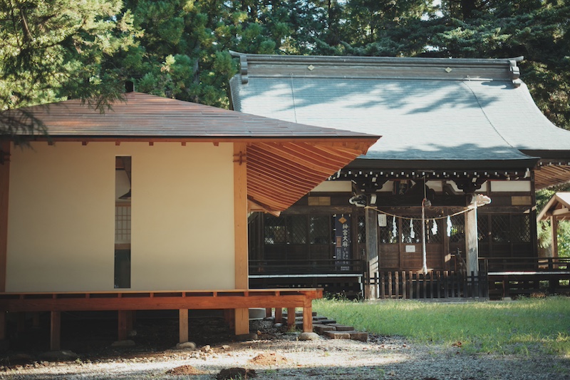 leaning timber frame anchors shrine office in japanese mountain valley - 3