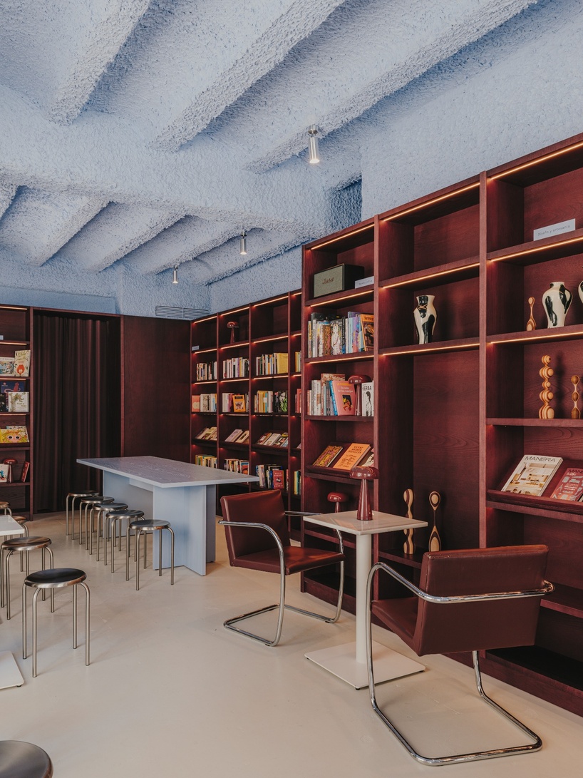 burgundy wood and blue ceilings shape café, bookshop, and wine bar in valencia - 3