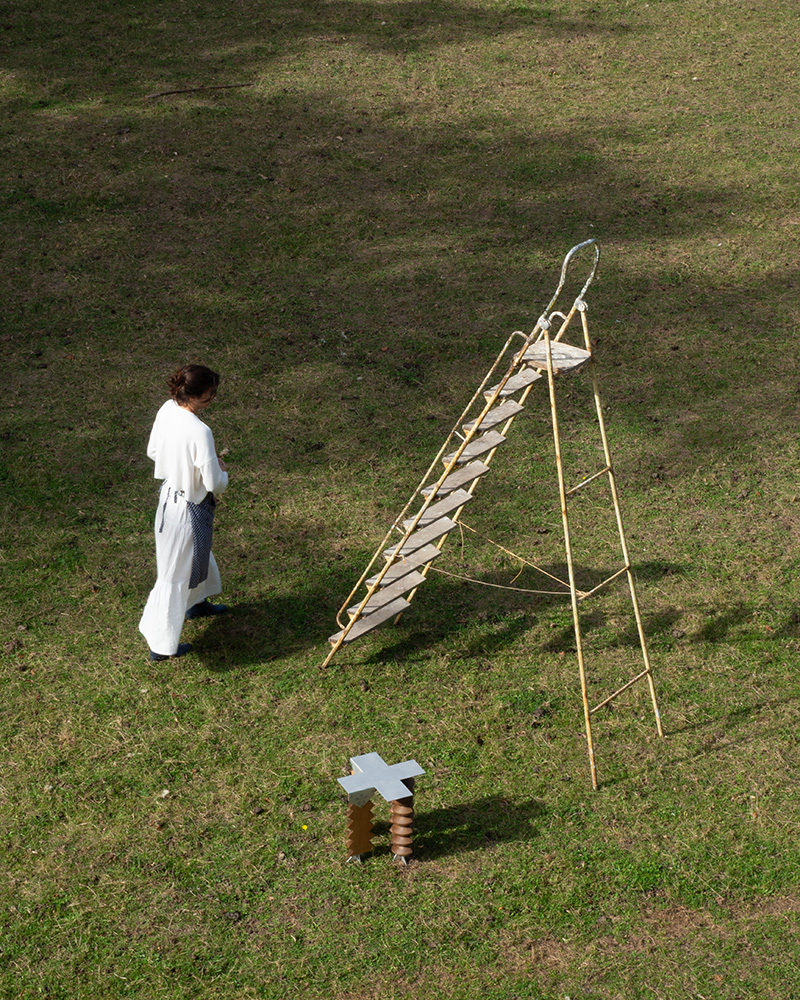 LE PRESSOIR sculptural stool on view in a green yard with a ladder