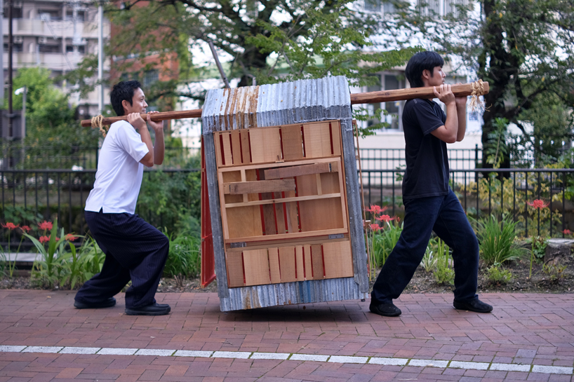 two people carry portable micro pavilion