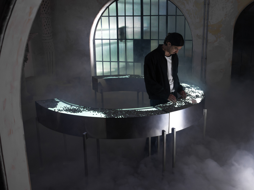 steel spheres moving across curved glass frame leonardo garza’s sensory installation for BYREDO - 1