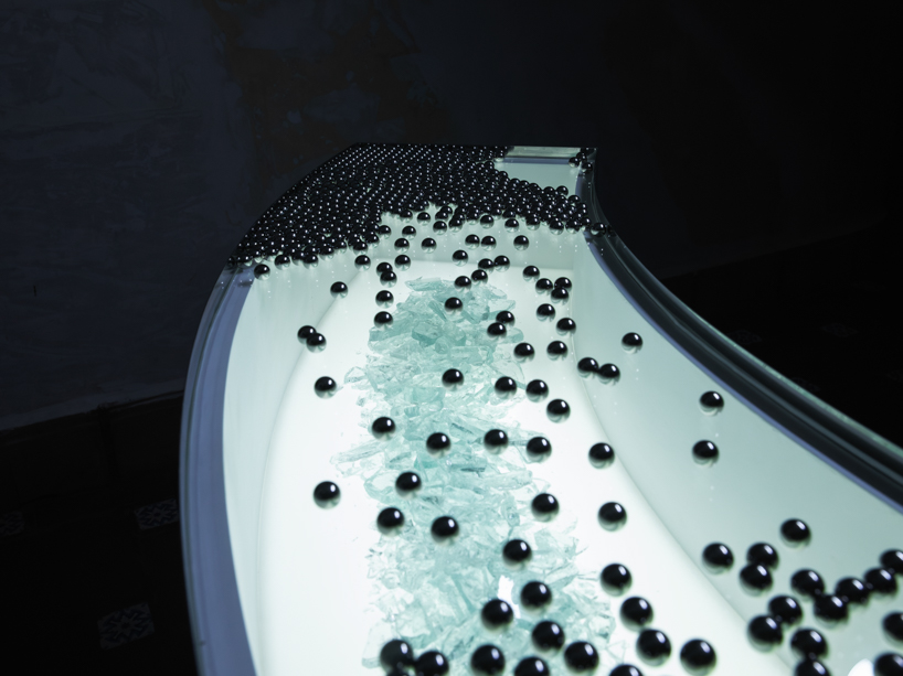 steel spheres moving across curved glass frame leonardo garza’s sensory installation for BYREDO - 3