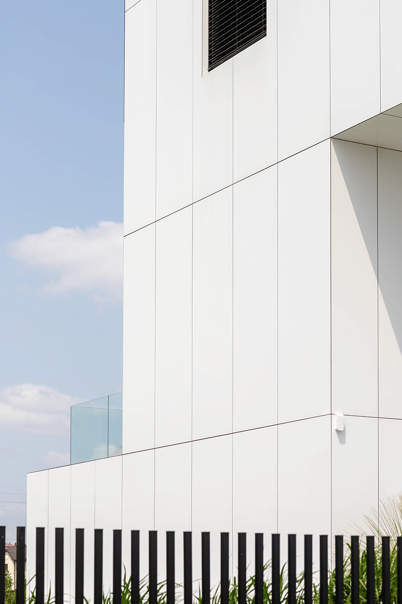 white aluminum cladding wraps tetris-like residence along lake in poland - 7