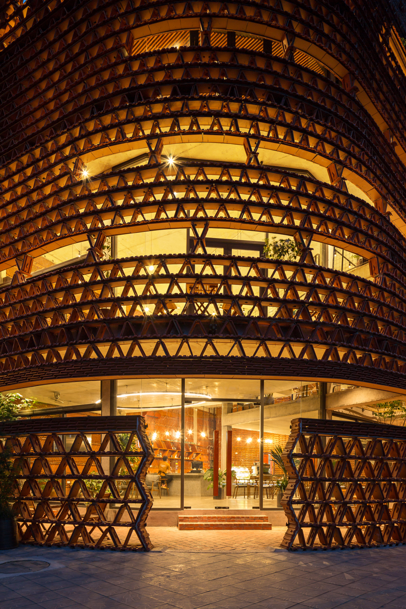 A+H architects wraps vietnam café with large, rotating glass doors