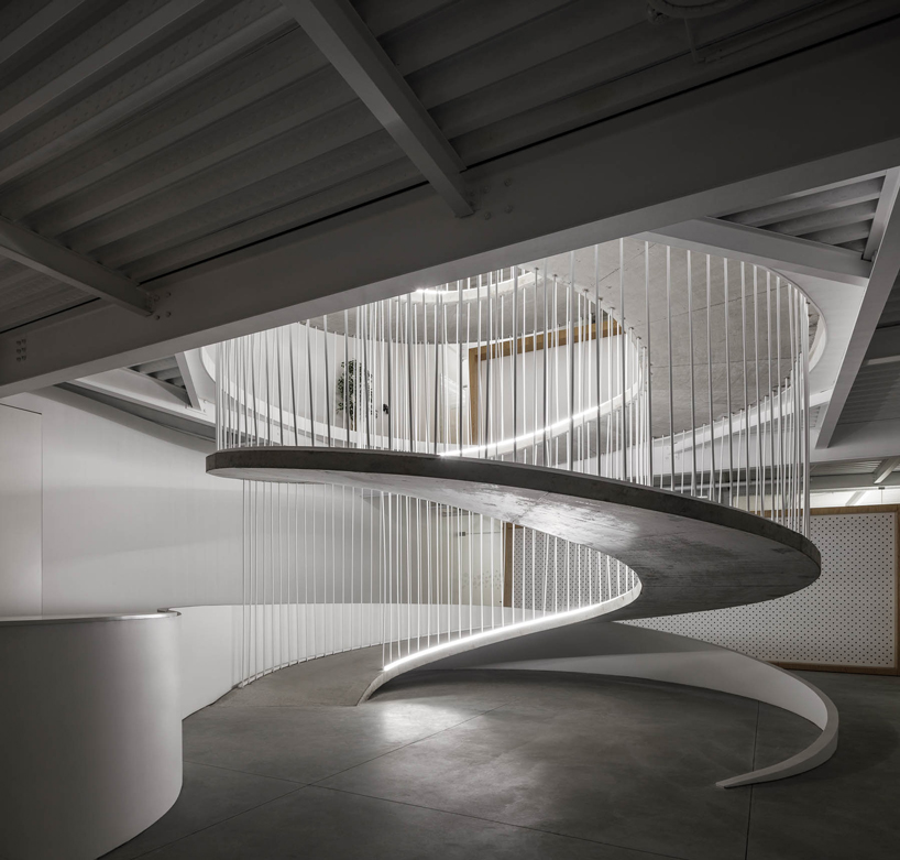 a spiral staircase connects paulo merlini's warehouse turned office in ...