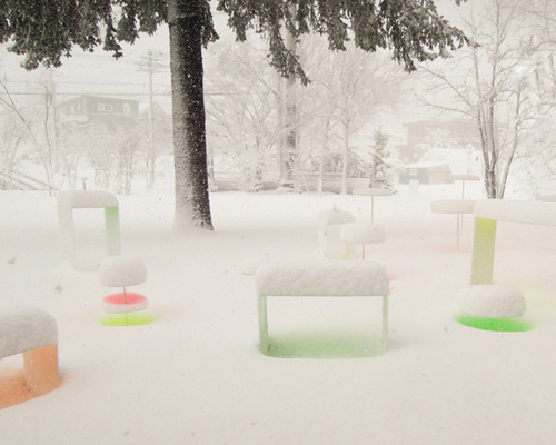 colored disks reflect off the snowy landscape by toshihiko shibuya