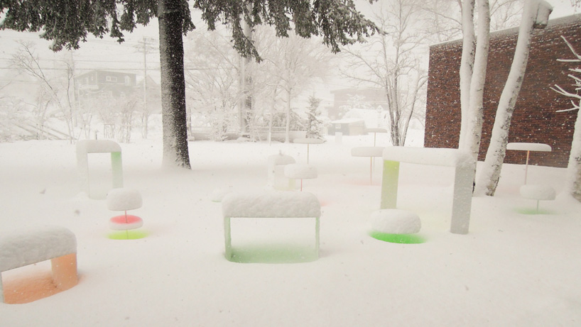 colored disks reflect off the snowy landscape by toshihiko shibuya