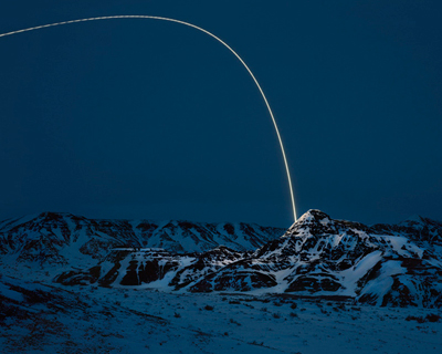 beams of light illuminate the snowy landscape by kevin cooley