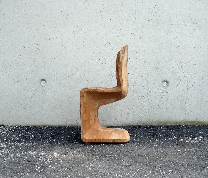 a chainsaw carves the wooden panton chair from a beech tree