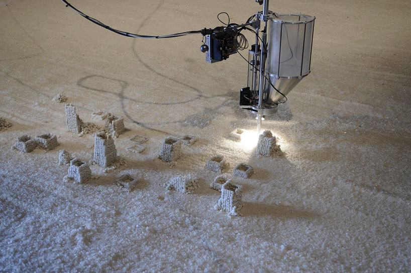 robot builds salt sculptures as visitors watch from a hot tub
