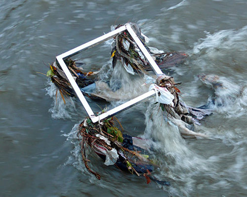 eben goff submerges flood cubes in debris-filled waterways