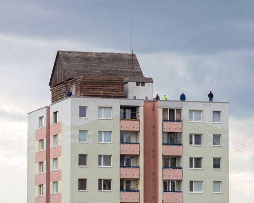 tomas dzadon places log cottages onto kosice tower rooftop 
